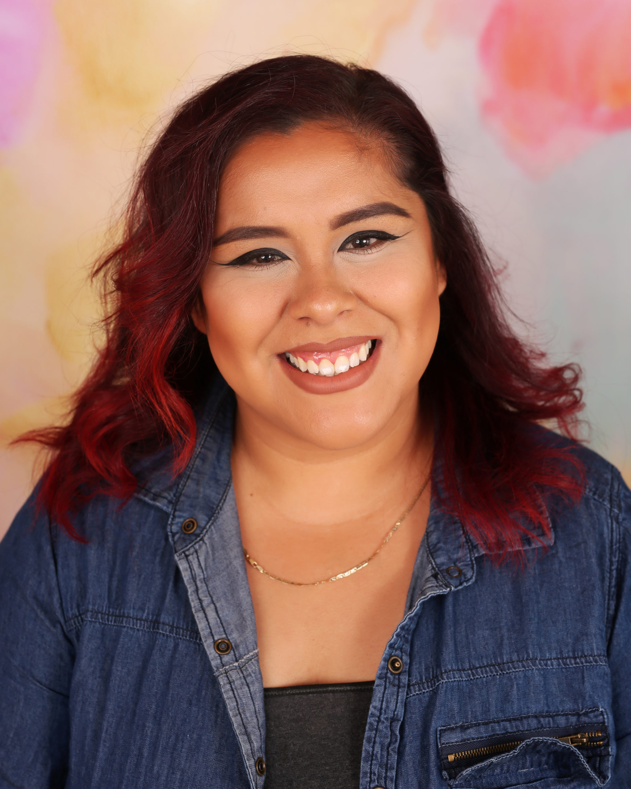 A woman with red hair smiling for the camera.