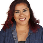 A woman with red hair smiling for the camera.