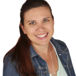 A woman wearing a jean jacket and smiling.